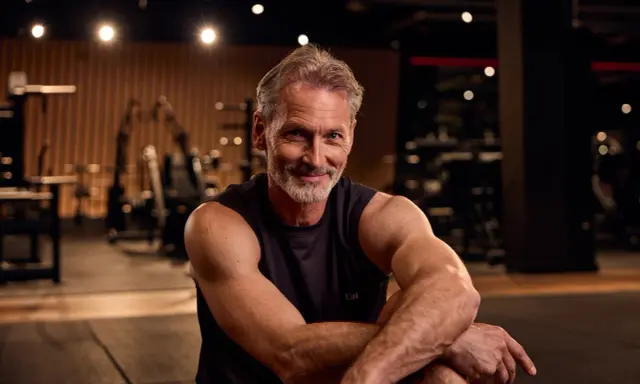 Ein fitter Mann über 50 im Fitnessstudio, bereit für den Muskelaufbau.