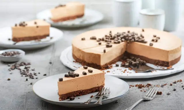 Ein cremiger no bake cheesecake mit Schokoladenstückchen, auf Tellern serviert.