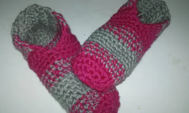 Ett par handvirkade tofflor i rosa och grått. Perfekta för mysiga hemmakvällar.