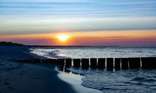 Zachód słońca nad Bałtykiem, falochrony i plaża w Sarbinowie. Piękne atrakcje Sarbinowo.