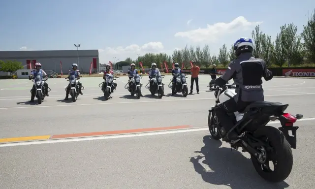 Grupo de motoristas en formación, listos para practicar con sus motos carmet a1 en un circuito.