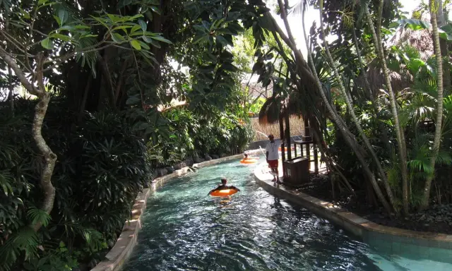 Un día perfecto para viajar a Bali con niños, disfrutando de un río tranquilo rodeado de exuberante vegetación tropical.