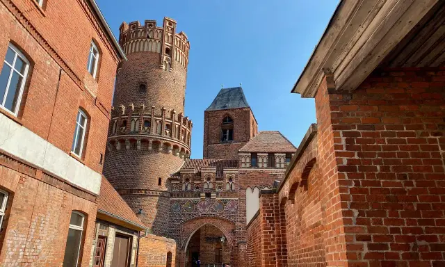 Historische Backsteinarchitektur mit einem runden Turm und Torbogen. Ein tolles Motiv für Ausflugsziele Sachsen-Anhalt.