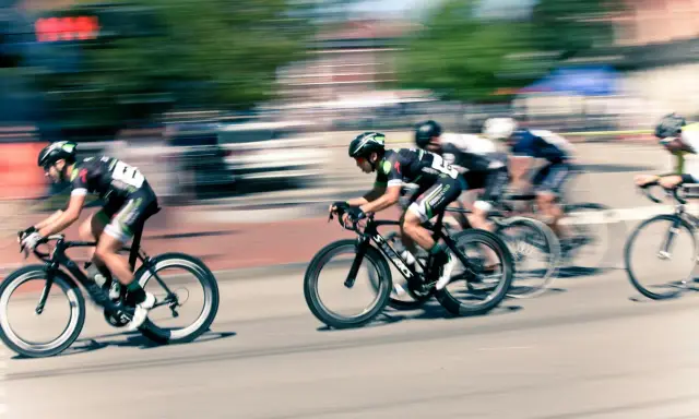 Ciclistas en carrera, capturados con un barrido fotográfico que resalta la velocidad y el movimiento.