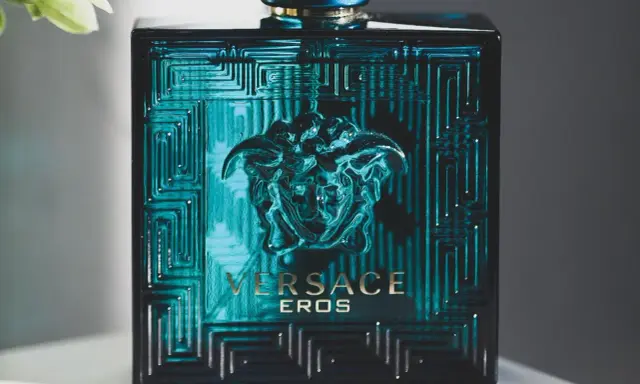 Butelka perfum męskich Versace Eros w turkusowym kolorze z greckim wzorem i głową Meduzy.