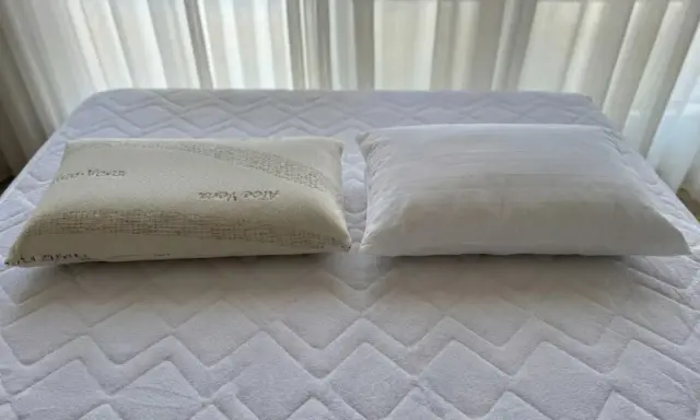 Dos almohadas sobre un colchón: una de fibra con Aloe Vera y otra viscoelástica. ¿Qué es mejor almohada de fibra o viscoelástica?