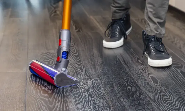 Aspiradora moderna limpia suelo vinílico con acabado de madera. Paso a paso, como limpiar suelo vinilico para un hogar impecable.