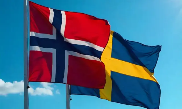 Flaga Norwegii i Szwecji powiewają na tle błękitnego nieba.