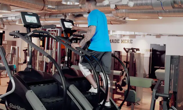 Mann trainiert auf einem Stairmaster im Fitnessstudio.