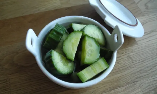Snabbsaltad gurka i en vit skål, redo att serveras. Enkel och god tillbehör.