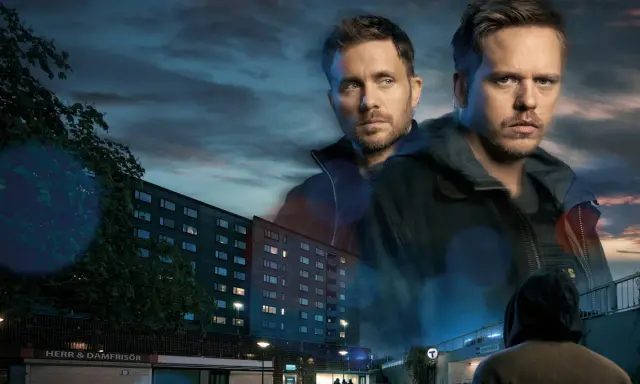 Två män i förgrunden, en lägenhetsbyggnad och en tunnelbanenedgång i bakgrunden. En scen från en tv4 film.