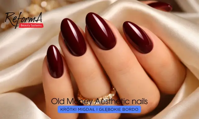 Eleganckie paznokcie w odcieniu głębokiego bordo, o migdałowym kształcie, ozdobione złotym pierścionkiem.