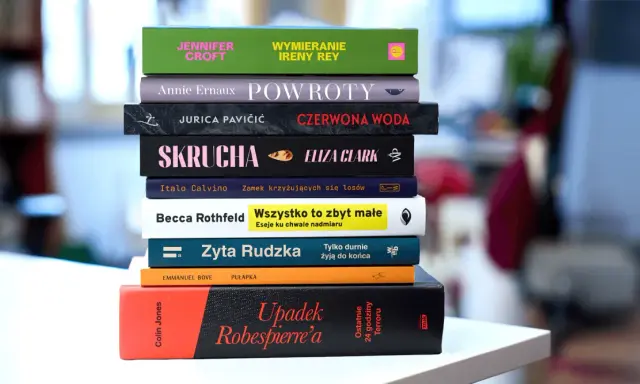 Stos książek, w tym "Upadek Robespierre'a" i "Wszystko to zbyt małe". Anna Klara Majewska mogłaby je czytać.