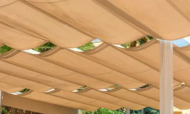 Techar patio económico con toldo de tela beige ondulado, creando un espacio sombreado y fresco.