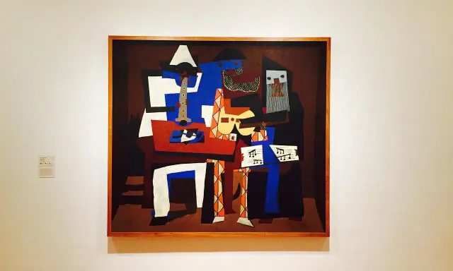 En kubistisk målning av Pablo Picasso föreställer musiker med instrument och noter.