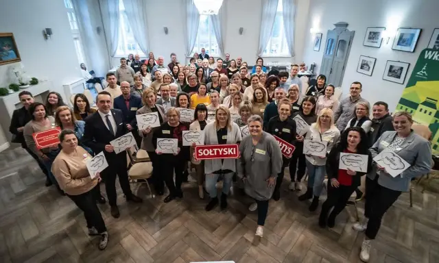 Grupa osób trzyma tabliczki z napisami, m.in. "SOŁTYSKI", "Podnosimy wyzwania", "Ale ENERGIA!".
