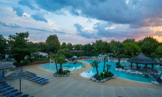 Villaggio vacanze con piscine azzurre, palme e lettini prendisole. Un angolo di paradiso, un vero tahiti camping village.
