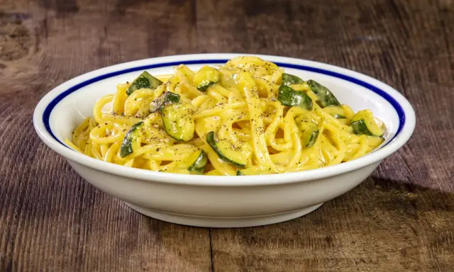Spaghetti cremosi con zucchine, un'interpretazione fresca della carbonara di zucchine, guarniti con pepe nero macinato.