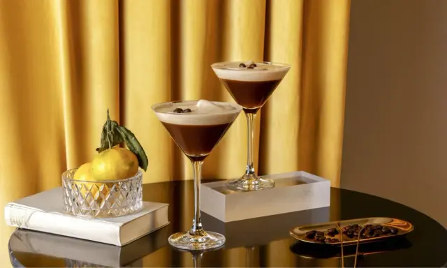 Zwei elegante Gläser mit cremigem Espresso-Martini-Look, garniert mit Kaffeebohnen. Ein alkoholfreier Genuss, der Luxus ausstrahlt.