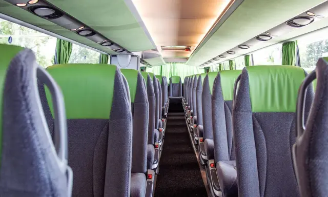 Leere Sitze im Bus, bereit für die Fahrt von Setúbal nach Lissabon. Grüne und graue Polster, Blick in den Gang.
