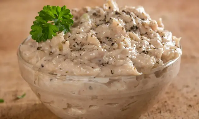 Pyszna pasta z tuńczyka w szklanej miseczce, posypana pieprzem i udekorowana natką pietruszki. Idealna na kanapki.