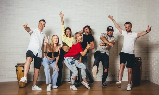 Grupa ludzi wesoło pozuje, gotowa do tańca zouk.