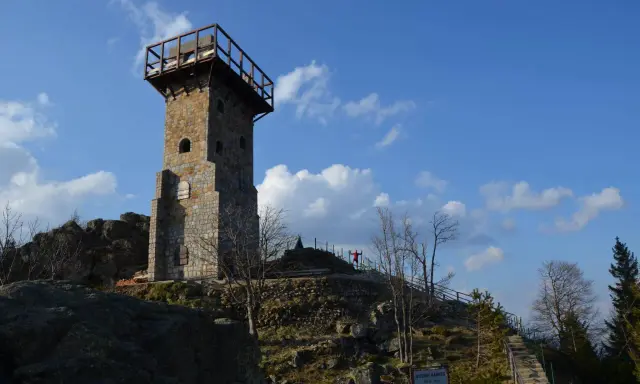 Wysoki kamień, wieża widokowa na szczycie góry, z drewnianym tarasem i schodami prowadzącymi do niej.