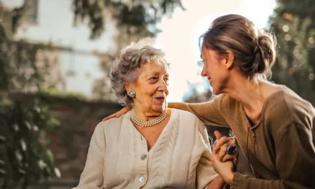 Un legame forte tra madre e figlia adulta, un abbraccio che simboleggia la dipendenza dalla madre in età adulta, ma anche amore e cura.