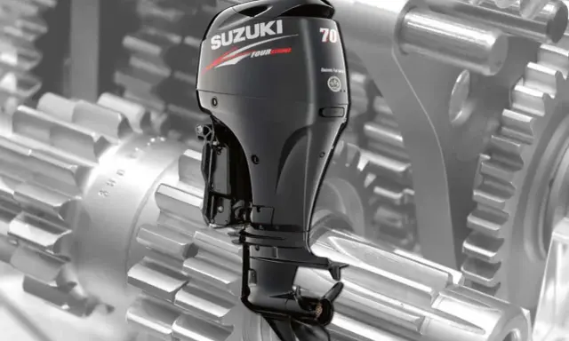 Moteur hors-bord Suzuki DF 70, vu sur fond de rouages mécaniques. Une image pour la revue technique.