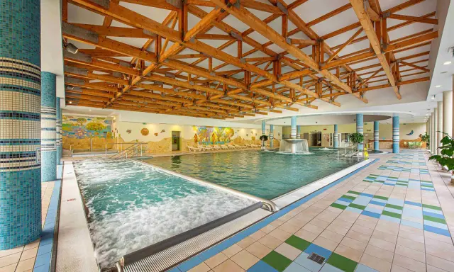 Wnętrze basenu z jacuzzi i kaskadą. Sprawdź bardejowskie termy cennik i zaplanuj relaks.