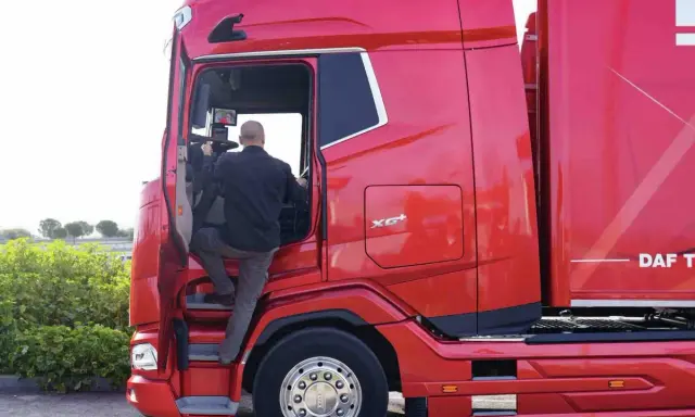 Hombre subiendo a un camión rojo DAF XG Plus.