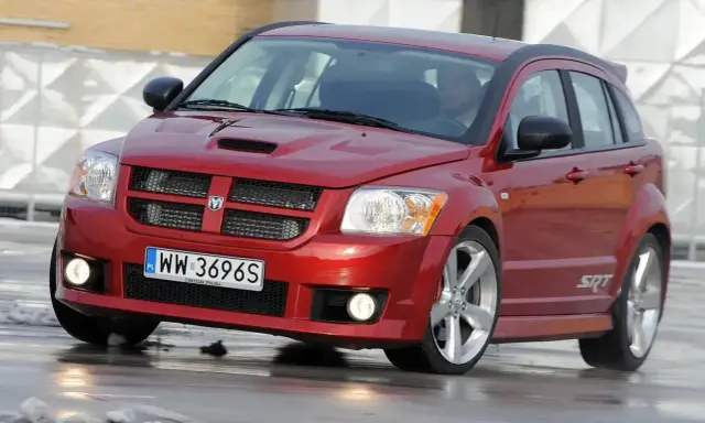 Czerwony Dodge Caliber SRT na mokrej nawierzchni. Wiele osób szuka **dodge caliber opinie** przed zakupem.