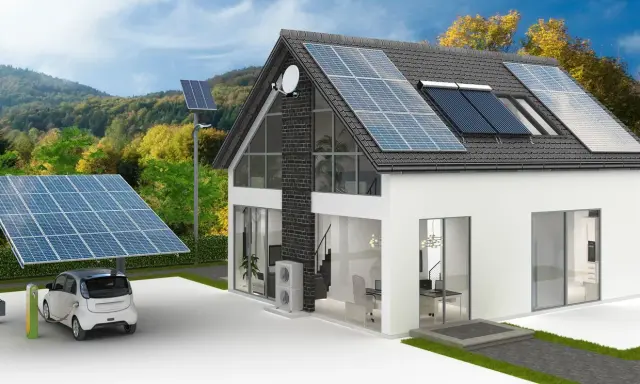 Une maison écologique autonome avec panneaux solaires sur le toit et un carport, une voiture électrique en charge.