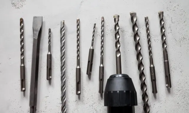 Variedad de tipos de mandriles para taladros, incluyendo brocas para concreto y un cincel, listos para cualquier trabajo.