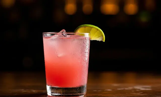 En svalkande Paloma drink med is och en limeklyfta, perfekt för en varm kväll.