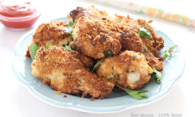 Alette di pollo croccanti in friggitrice ad aria, servite su un piatto azzurro con prezzemolo fresco e una ciotolina di ketchup.