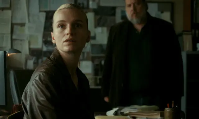 Kobieta w skórzanej kurtce i mężczyzna z brodą w tle, atmosfera napięcia w stylu thriller skandynawski film.