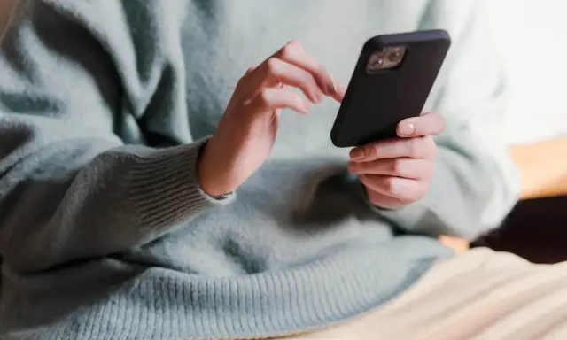 Dłonie piszą sms po kłótni, próbując załagodzić sytuację.
