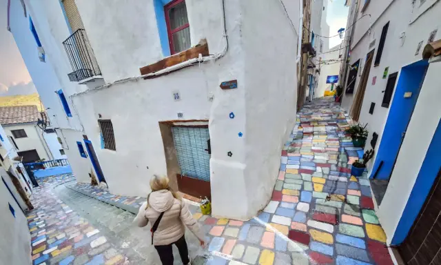 Callejuela de **Chelva pueblo azul**, con escalones de colores vibrantes y casas blancas adornadas con detalles azules.