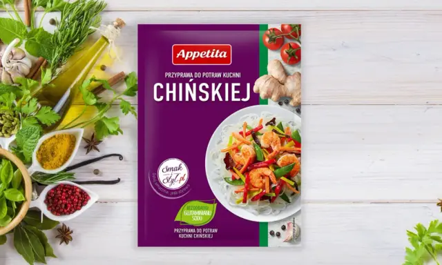 Opakowanie przyprawy do dań kuchni chińskiej Appetita. Obok świeże zioła, czosnek, imbir, pomidorki i składniki, jakie przyprawy do chińszczyzny.