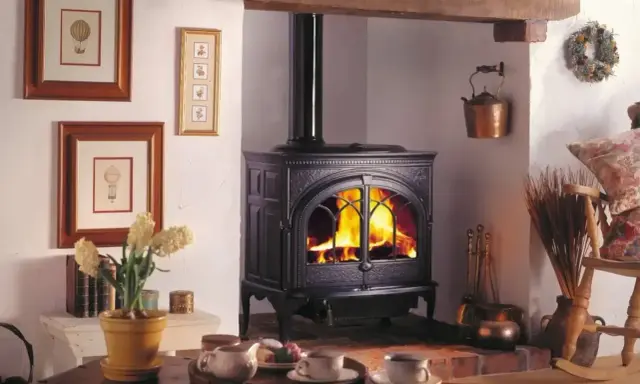 Przytulny pokój z palącym się piecem kaflowym, który jest idealnym rozwiązaniem, jak oświetlić pomieszczenie bez prądu.