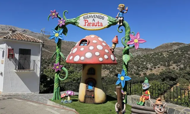Bienvenido a Parauta, inicio de la ruta del bosque encantado. Un duende saluda desde un arco con flores y un hongo mágico.