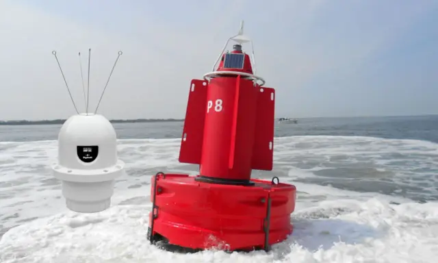 Deux bouées, une blanche avec des antennes et une rouge marquée "P8", flottent sur l'eau agitée, un petit bateau à l'horizon.