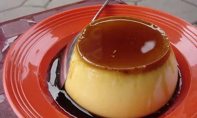 Un délicieux crème caramel, tout juste sorti du four, prêt à être dégusté. Sa texture onctueuse et son caramel doré invitent à la gourmandise.