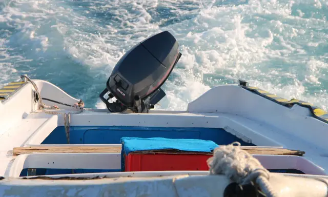 Moteur hors-bord 2 temps sur un bateau en mouvement. Un entretien régulier assure la fiabilité pour vos sorties en mer.