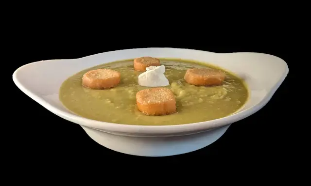 Soupe de pois cassés onctueuse, garnie de croûtons dorés et d'une touche de crème. Un délice réconfortant.