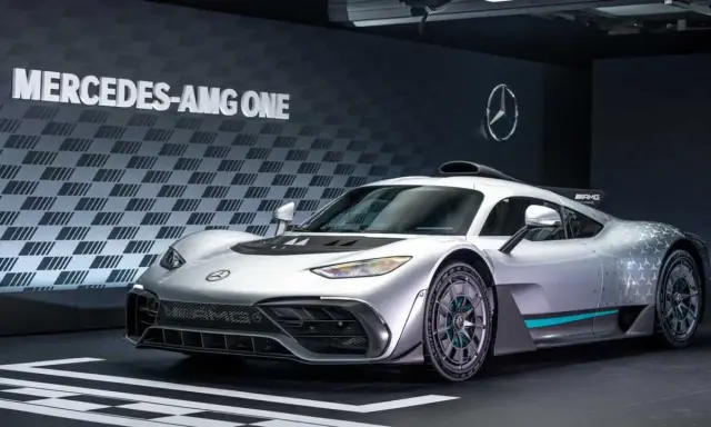Silberner Mercedes-AMG ONE mit auffälligem Design und dem Schriftzug "MERCEDES-AMG ONE" im Hintergrund.
