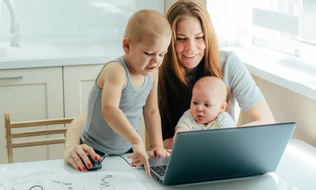 Mama z dwójką dzieci przy laptopie, starszak pokazuje coś na ekranie. To ich wspólny artystyczny projekt, może nawet z elementami art 188 kp.