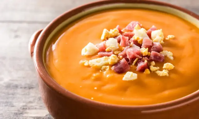Un cuenco de salmorejo, la deliciosa comida típica de Córdoba, adornado con trocitos de huevo duro y jamón serrano.