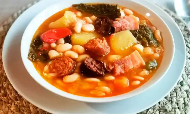 Un reconfortante plato de cocido montañés, con alubias blancas, patatas, chorizo, morcilla y berza.